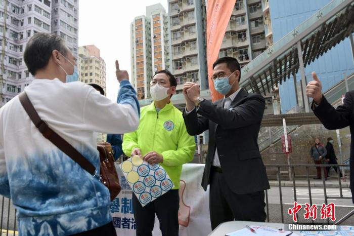 3月11日上午，香港市民于慈云山街站签名支持完善香港选举制度，确保爱国者治港。图为香港市民向教育局局长杨润雄(右一)竖大拇指点赞。中新社记者 李志华 摄