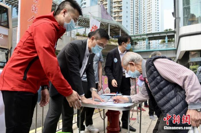 3月11日上午，香港市民于慈云山街站签名支持完善香港选举制度，确保爱国者治港，香港特区政府教育局局长杨润雄(左二)到场参与活动。图为市民签名支持。中新社记者 李志华 摄