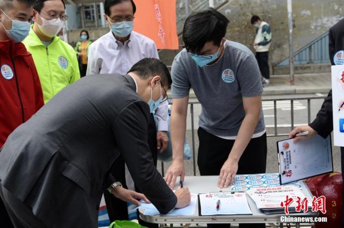 3月11日上午，香港市民于慈云山街站签名支持完善香港选举制度，确保爱国者治港。图为香港特区政府教育局局长杨润雄签名支持。中新社记者 李志华 摄