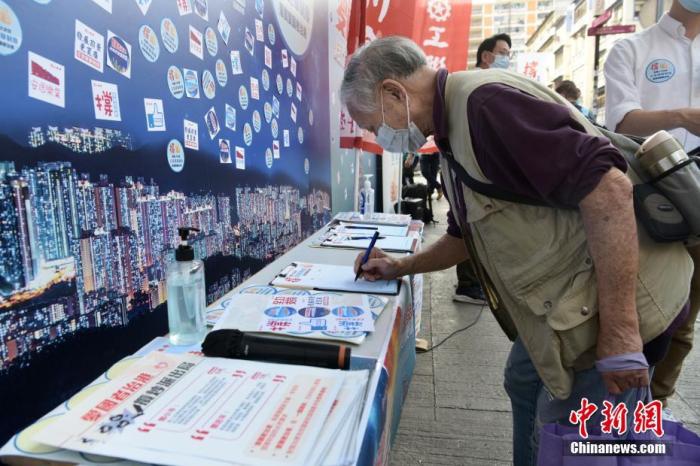 3月12日下午，香港市民到土瓜湾街站签名支持完善香港选举制度，落实“爱国者治港”。图为市民签名支持。
中新社记者 李志华 摄